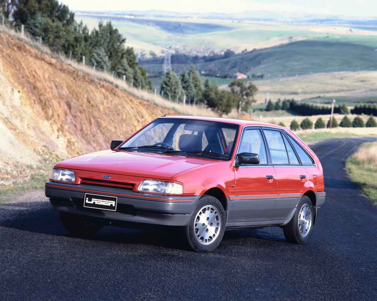 This archival image documents the 1989 Ford KE Laser Redline Series Hatchback Passenger Side Front End View on Country Road Fap-2011-3 and is preserved in the Ford Heritage Vault as part of Ford Motor Company's historic photographic archive. Free ...