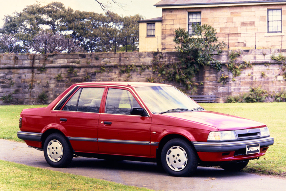 This archival image documents the 1987 Ford KE Laser Sedan Driver Side Front End View in Driveway FAP-2011-3 and is preserved in the Ford Heritage Vault as part of Ford Motor Company's historic photographic archive. Free for personal, non-commerci...