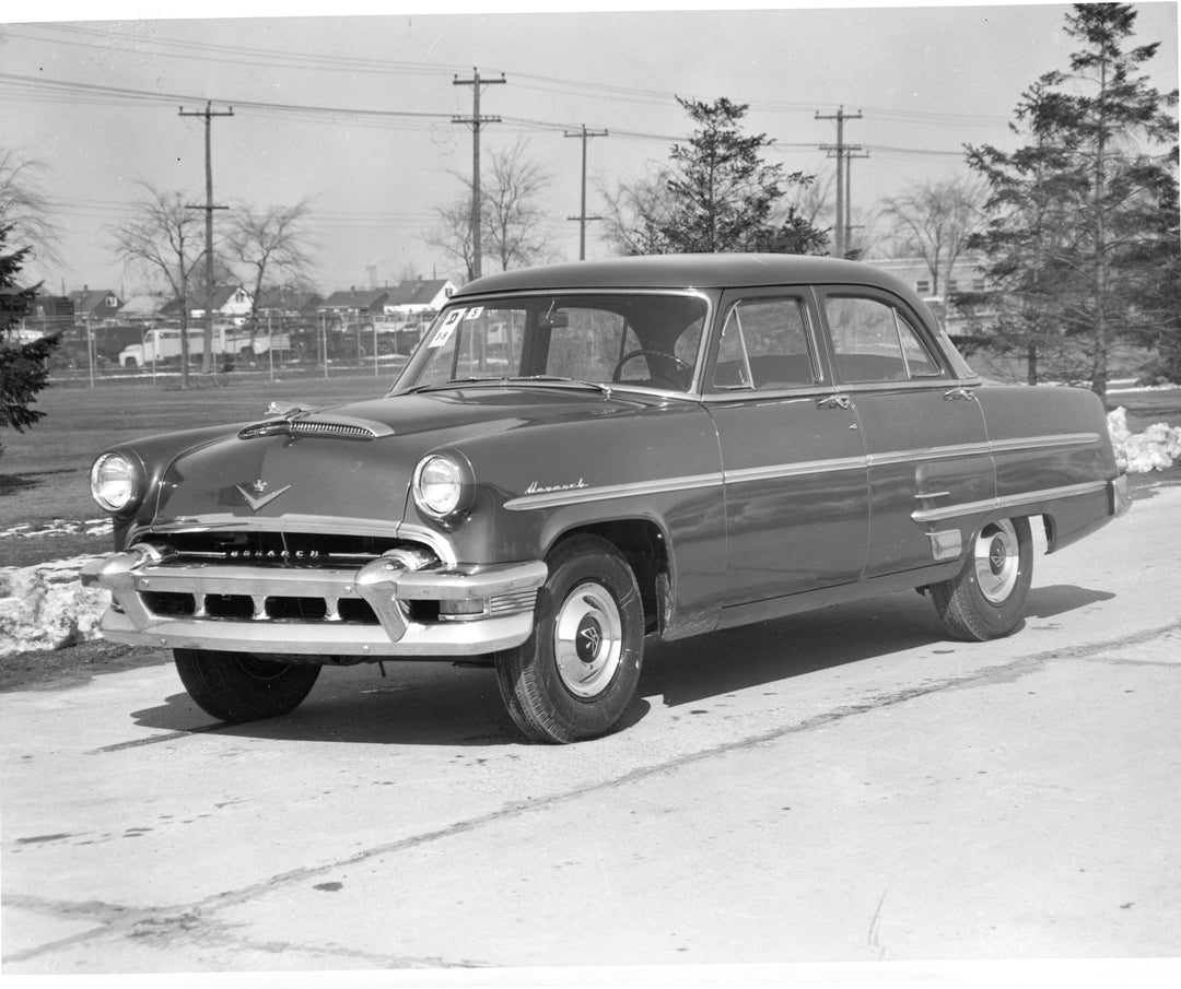 This archival image documents the 1954 Monarch sedan on scenic road with trees and is preserved in the Ford Heritage Vault as part of Ford Motor Company's historic photographic archive. Free for personal, non-commercial use. Ford Heritage Vault re...