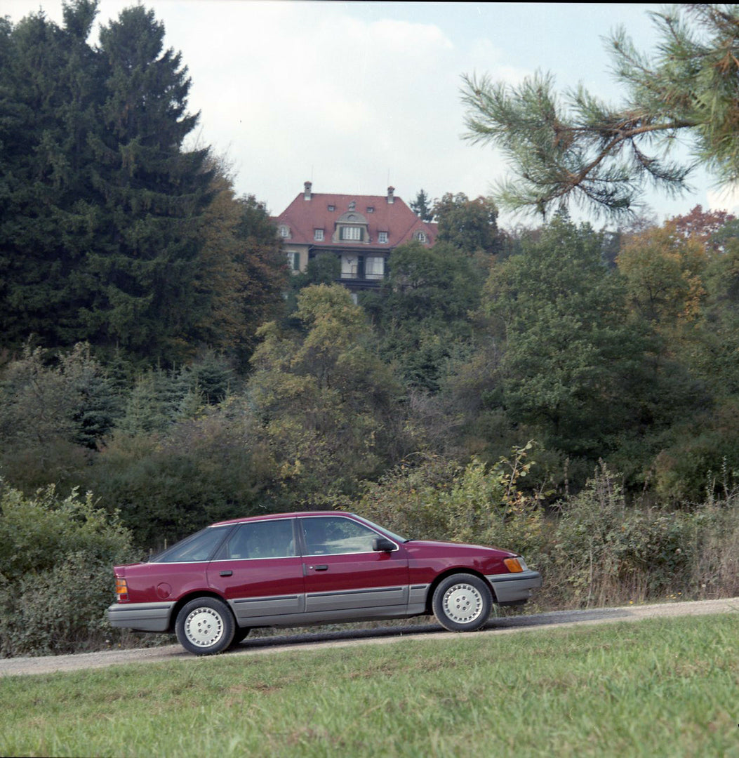 This archival image documents the 1986 Merkur Scorpio side view on scenic road with house in Cologne and is preserved in the Ford Heritage Vault as part of Ford Motor Company's historic photographic archive. Free for personal, non-commercial use. ...