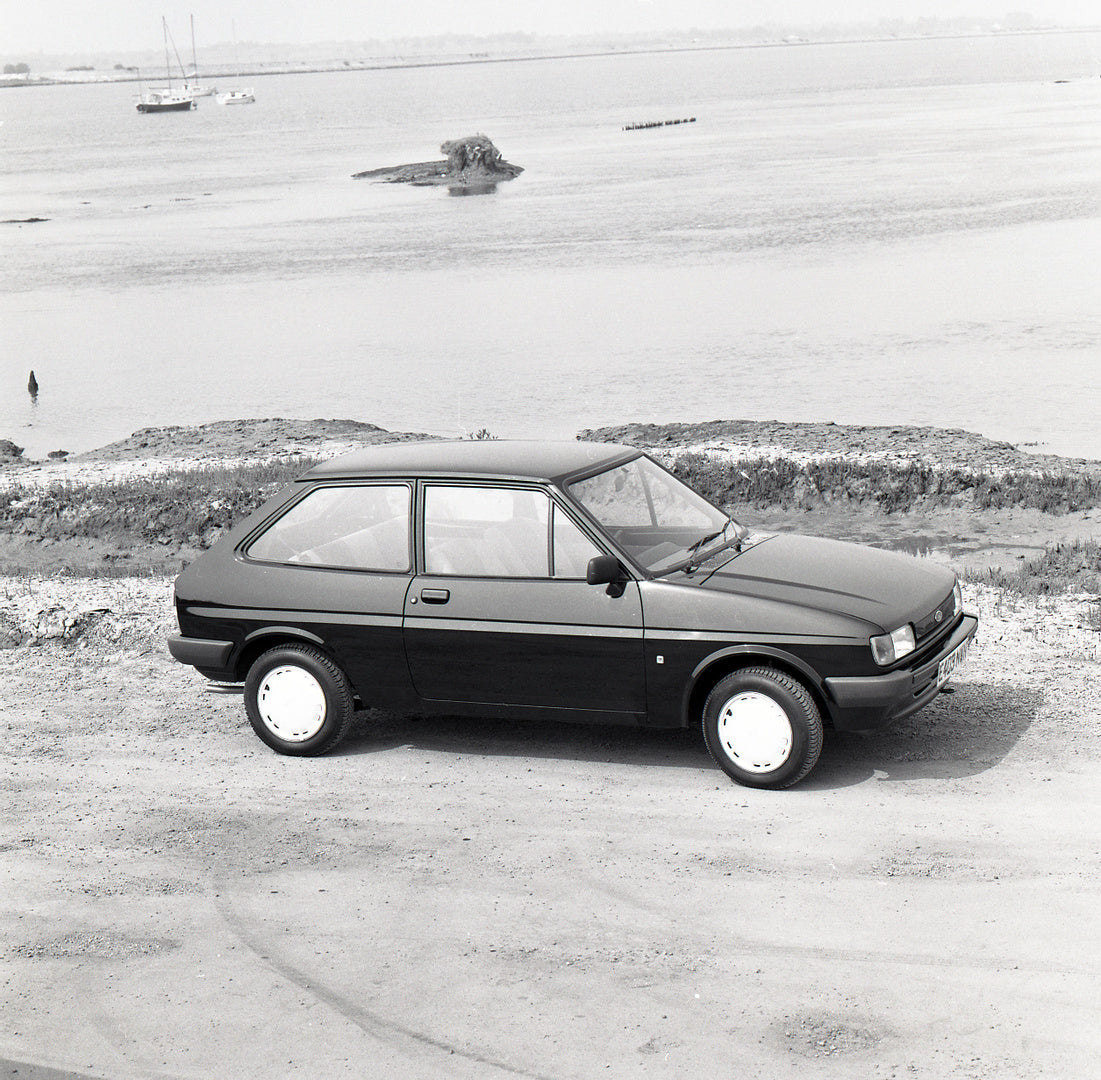 This archival image documents the 1987 Ford Fiesta Mark II Bonus side view on scenic beach and is preserved in the Ford Heritage Vault as part of Ford Motor Company's historic photographic archive. Free for personal, non-commercial use. Ford Herit...