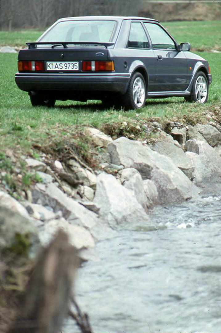 This archival image documents the 1989 Heritage Archive - 1988 Ford Escort Mark IV rear view near scenic river vertical shot and is preserved in the Ford Heritage Vault as part of Ford Motor Company's historic photographic archive. Free for person...