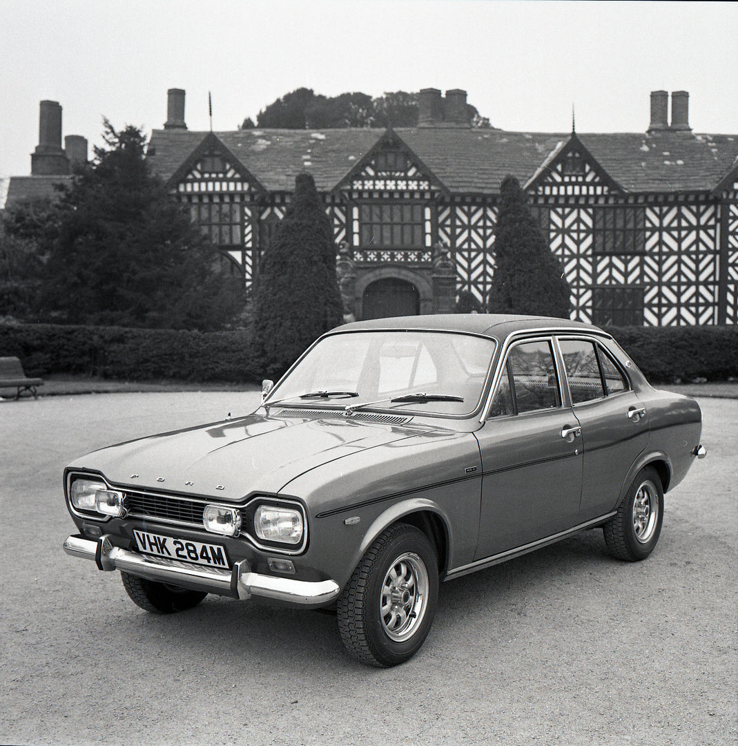 This archival image documents the 1974 Ford Escort Mark I 1300 E 4 Door in front of scenic house with trees and is preserved in the Ford Heritage Vault as part of Ford Motor Company's historic photographic archive. Free for personal, non-commercia...