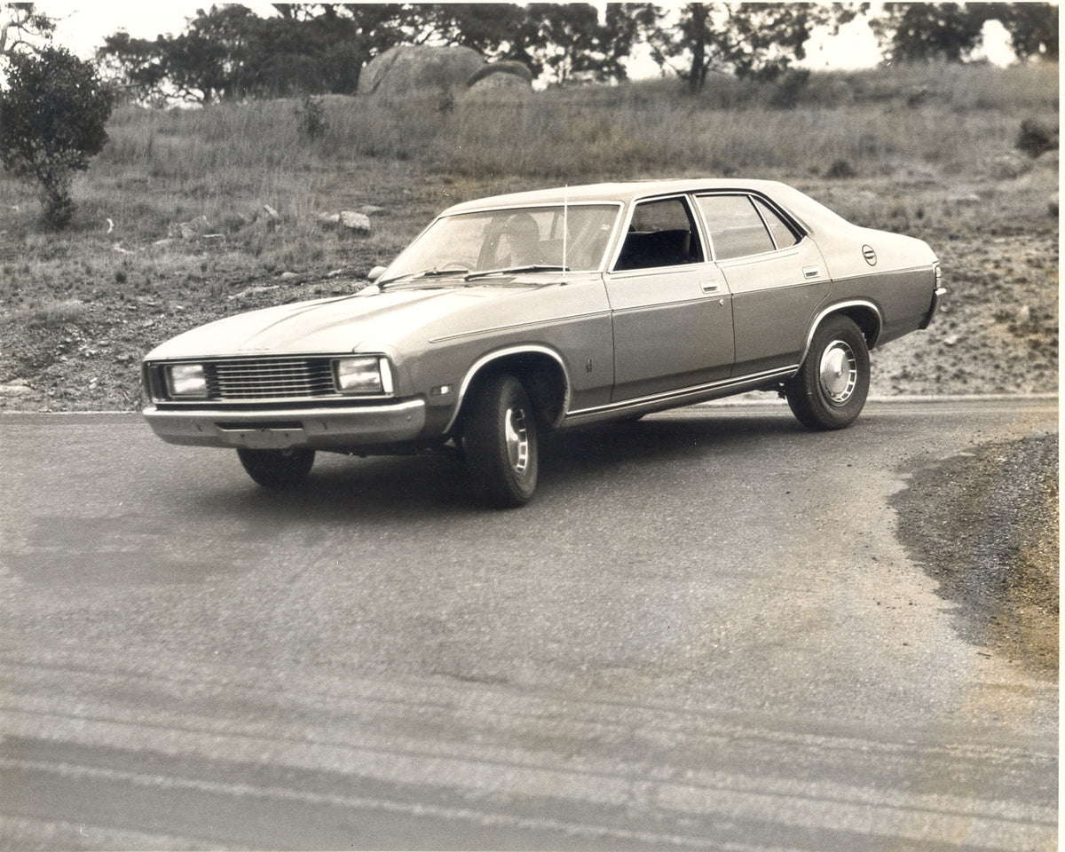 This archival image documents the 1976 Ford XC Falcon action shot on scenic road with trees and is preserved in the Ford Heritage Vault as part of Ford Motor Company's historic photographic archive. Free for personal, non-commercial use. Ford Heri...