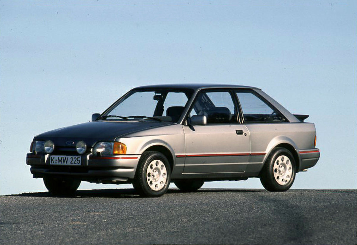 This archival image documents the 1986 Ford Escort Mark IV XR3i with scenic blue sky and is preserved in the Ford Heritage Vault as part of Ford Motor Company's historic photographic archive. Free for personal, non-commercial use. Ford Heritage Va...