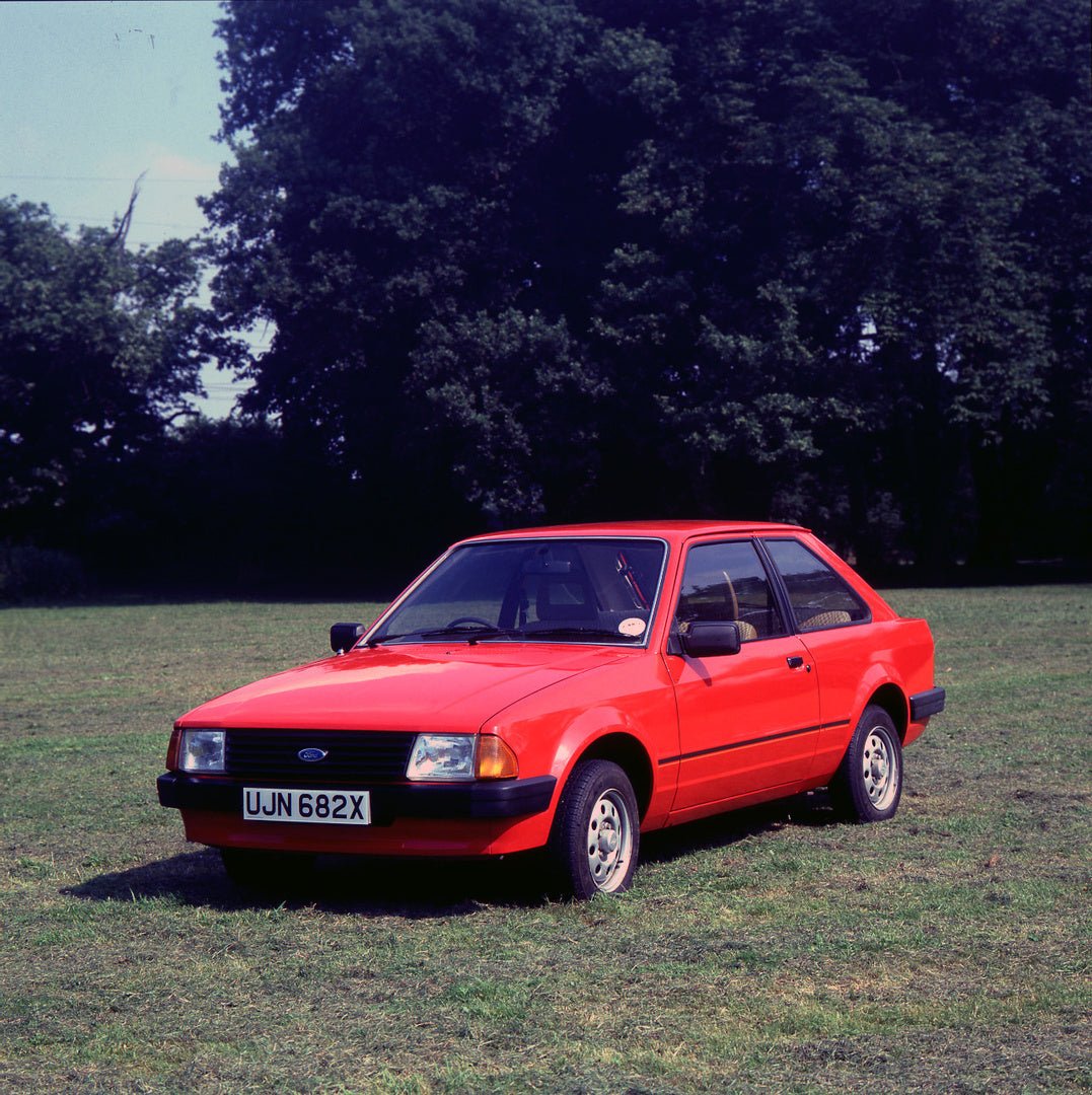 This archival image documents the 1981 Ford Escort Mark III L with scenic trees and is preserved in the Ford Heritage Vault as part of Ford Motor Company's historic photographic archive. Free for personal, non-commercial use. Ford Heritage Vault r...