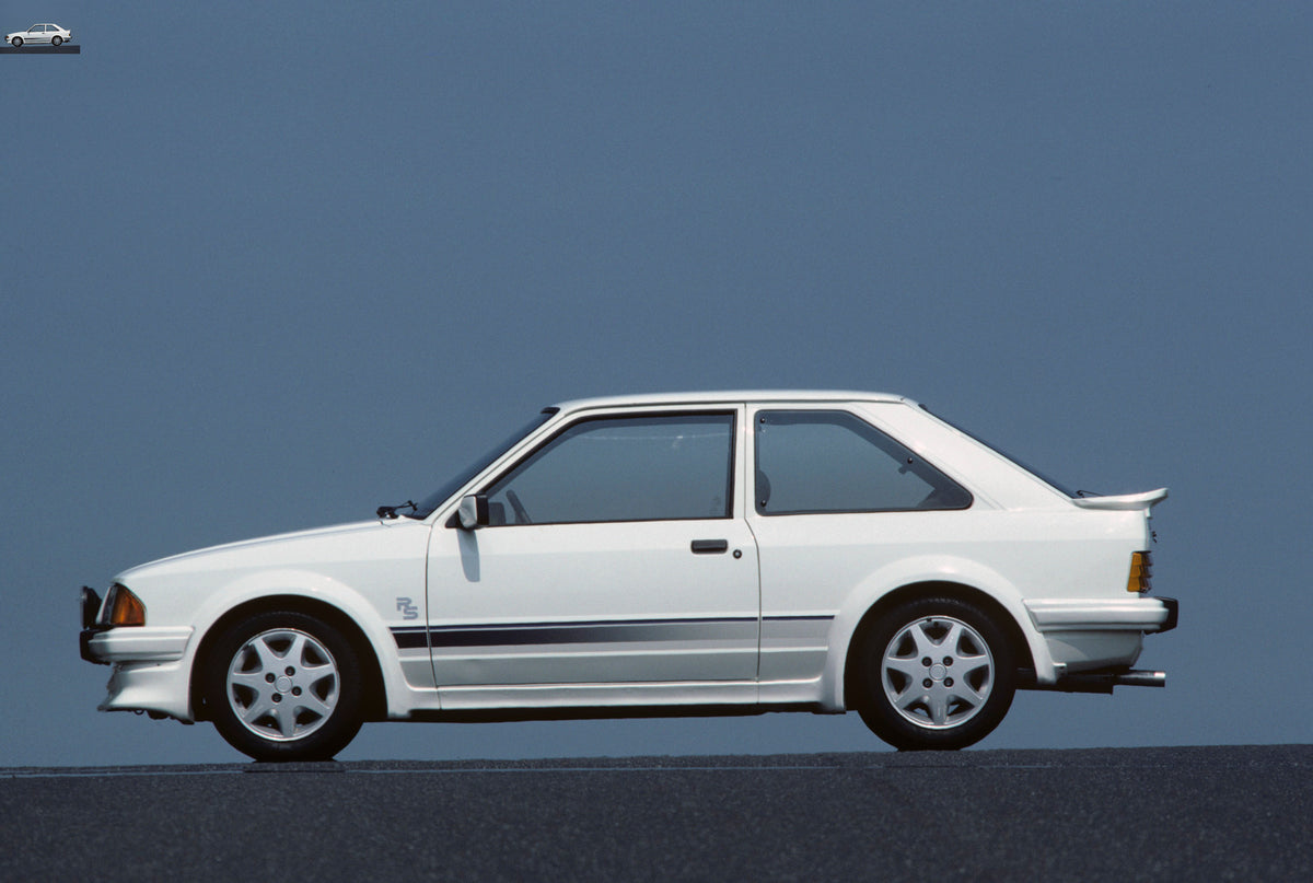 This archival image documents the 1984 Ford Escort Mark III RS Turbo side view with scenic blue sky and is preserved in the Ford Heritage Vault as part of Ford Motor Company's historic photographic archive. Free for personal, non-commercial use. F...
