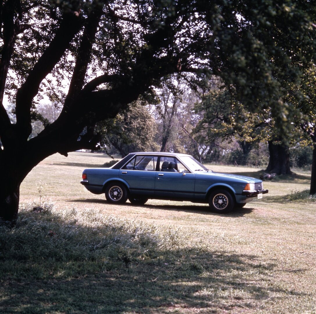 This archival image documents the 1977 Ford Granada GL under scenic trees and is preserved in the Ford Heritage Vault as part of Ford Motor Company's historic photographic archive. Free for personal, non-commercial use. Ford Heritage Vault referen...