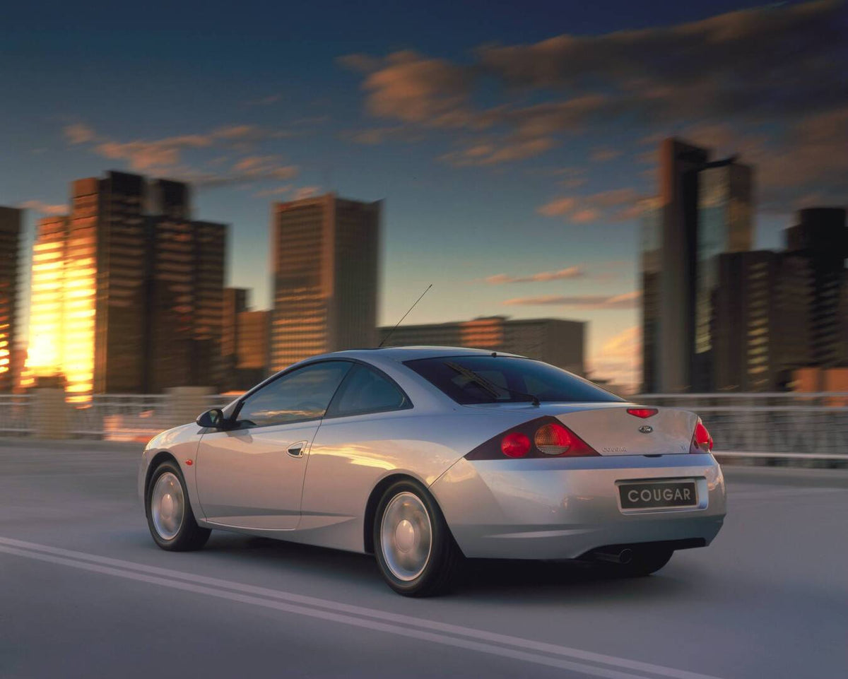 This archival image documents the 1998 Ford Cougar rear view action shot with cityscape AR-2002-213709 and is preserved in the Ford Heritage Vault as part of Ford Motor Company's historic photographic archive. Free for personal, non-commercial use...