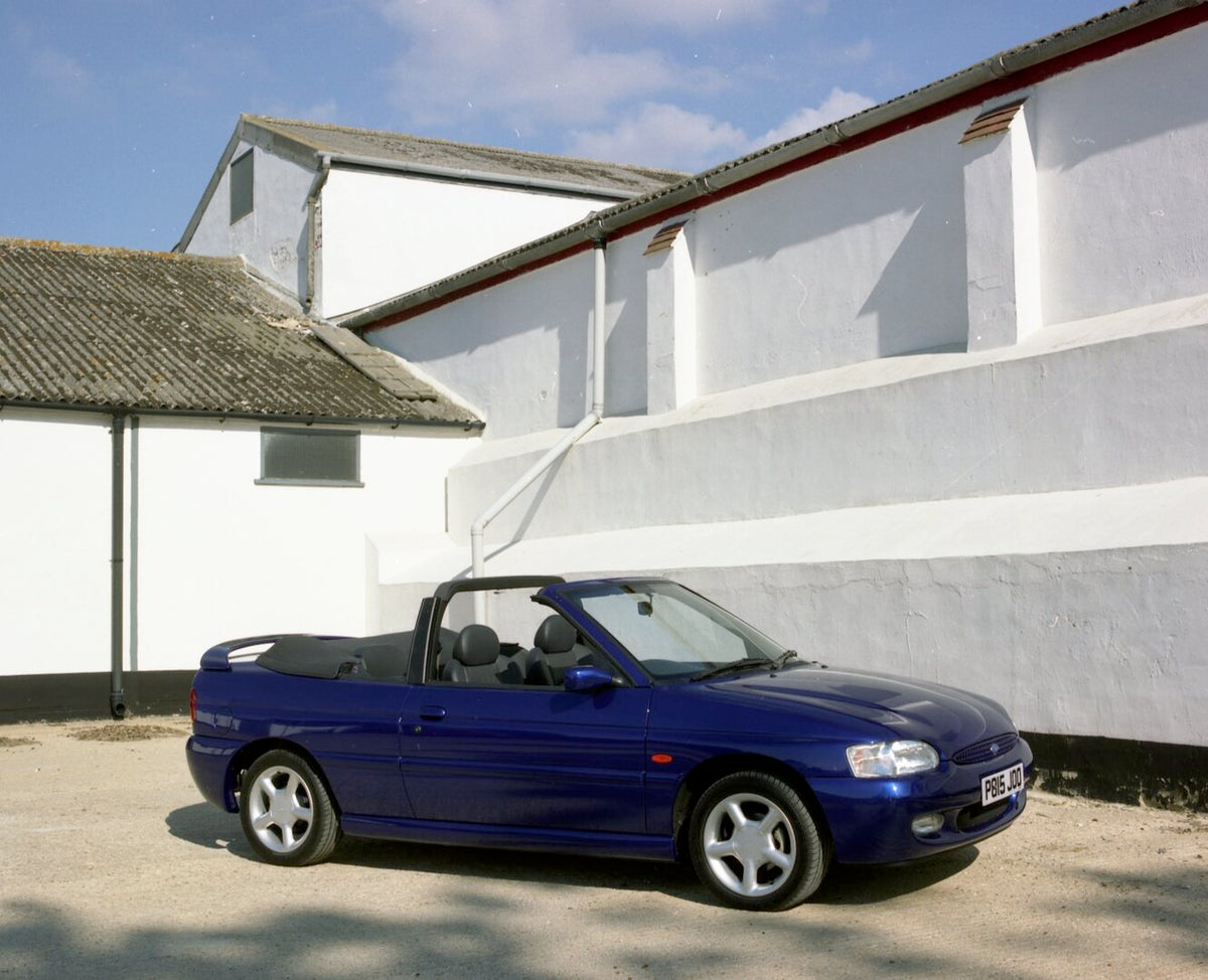 This archival image documents the 1996 Ford Escort Mark VI Cabriolet Ghia in front of building and is preserved in the Ford Heritage Vault as part of Ford Motor Company's historic photographic archive. Free for personal, non-commercial use. Ford H...