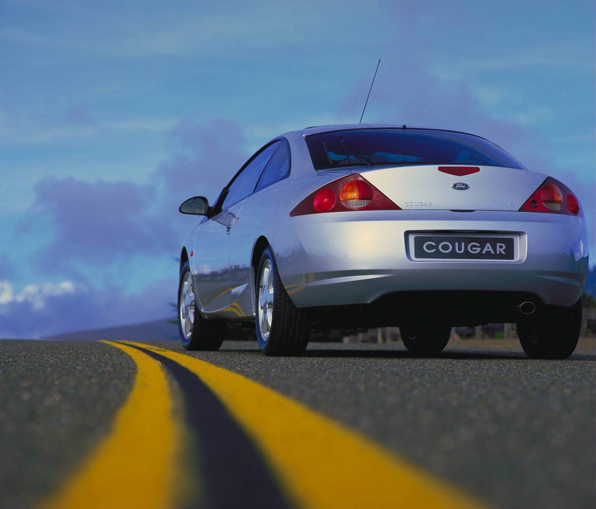 This archival image documents the 1998 Ford Cougar rear view on road AR-2002-213709 and is preserved in the Ford Heritage Vault as part of Ford Motor Company's historic photographic archive. Free for personal, non-commercial use. Ford Heritage Vau...
