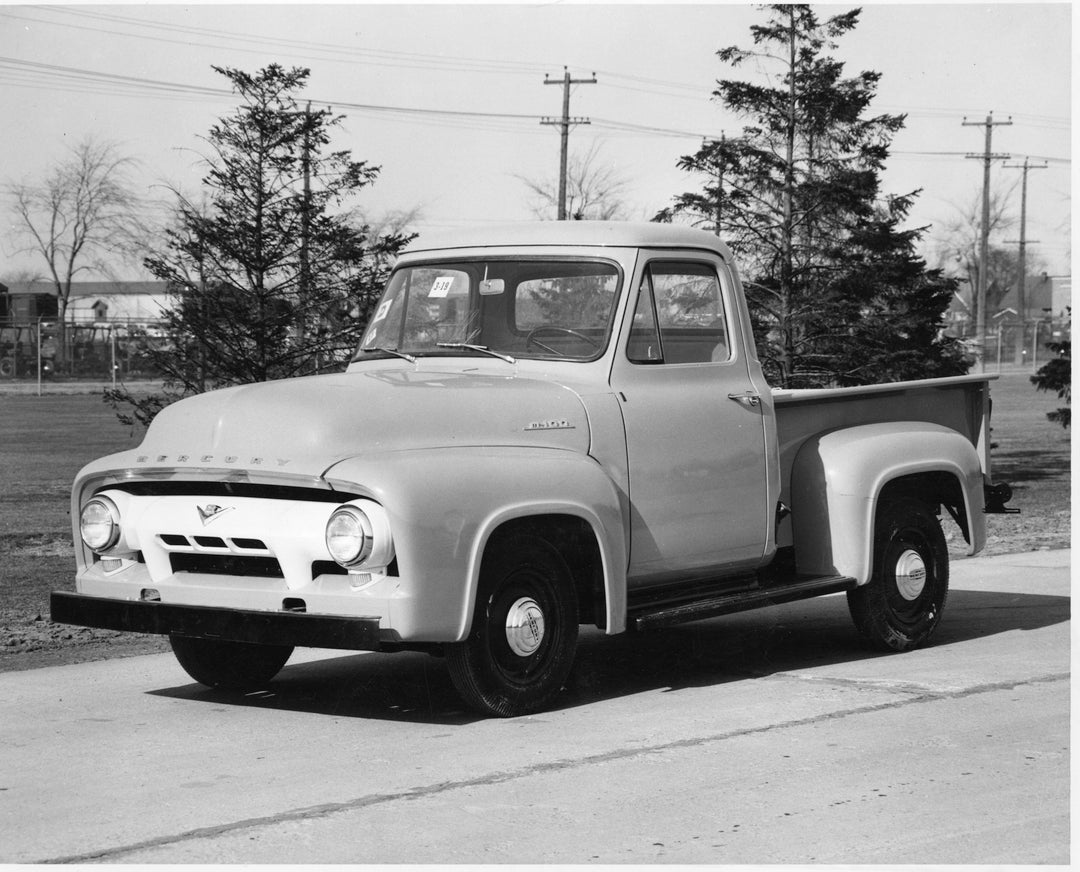 This archival image documents the 1954 Mercury M-100 on scenic road with trees and is preserved in the Ford Heritage Vault as part of Ford Motor Company's historic photographic archive. Free for personal, non-commercial use. Ford Heritage Vault re...