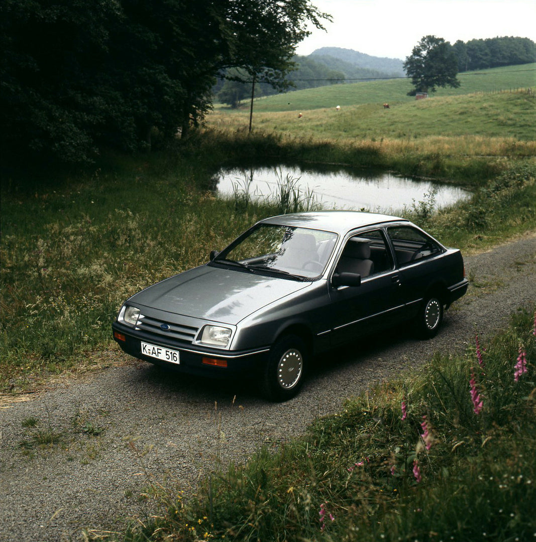 This archival image documents the 1983 Ford Sierra Mark I L on scenic road with pond and is preserved in the Ford Heritage Vault as part of Ford Motor Company's historic photographic archive. Free for personal, non-commercial use. Ford Heritage Va...