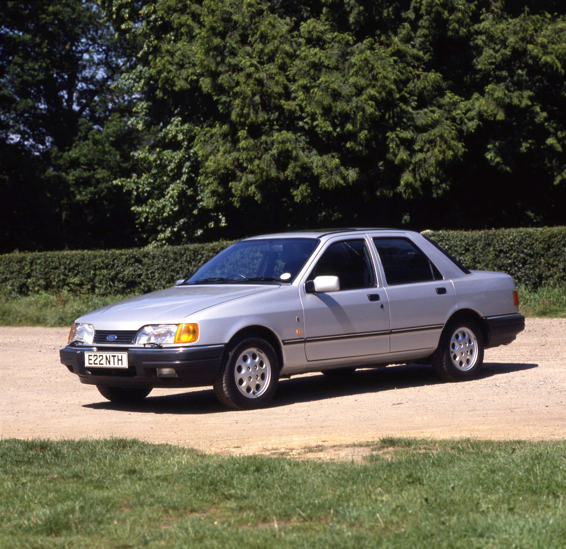 This archival image documents the 1987 Ford Sierra Mark II Sapphire 2.0i Ghia on scenic road with trees and is preserved in the Ford Heritage Vault as part of Ford Motor Company's historic photographic archive. Free for personal, non-commercial us...
