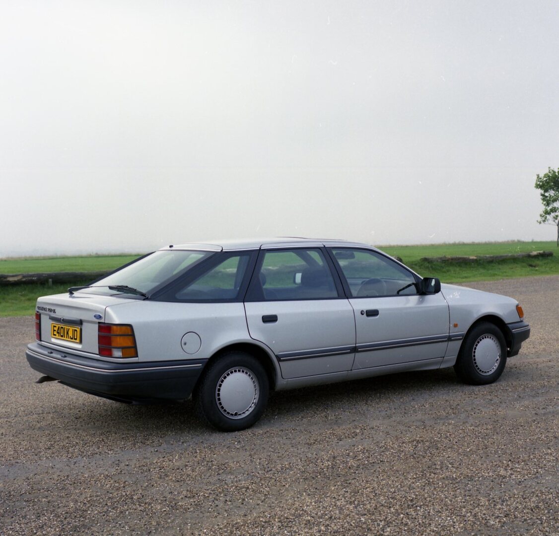 This archival image documents the 1987 Ford Granada Mark III GL rear view on scenic road and is preserved in the Ford Heritage Vault as part of Ford Motor Company's historic photographic archive. Free for personal, non-commercial use. Ford Heritag...