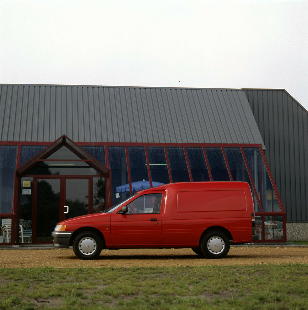 This archival image documents the 1990 Ford Escort Mark IV van in front of building and is preserved in the Ford Heritage Vault as part of Ford Motor Company's historic photographic archive. Free for personal, non-commercial use. Ford Heritage Vau...