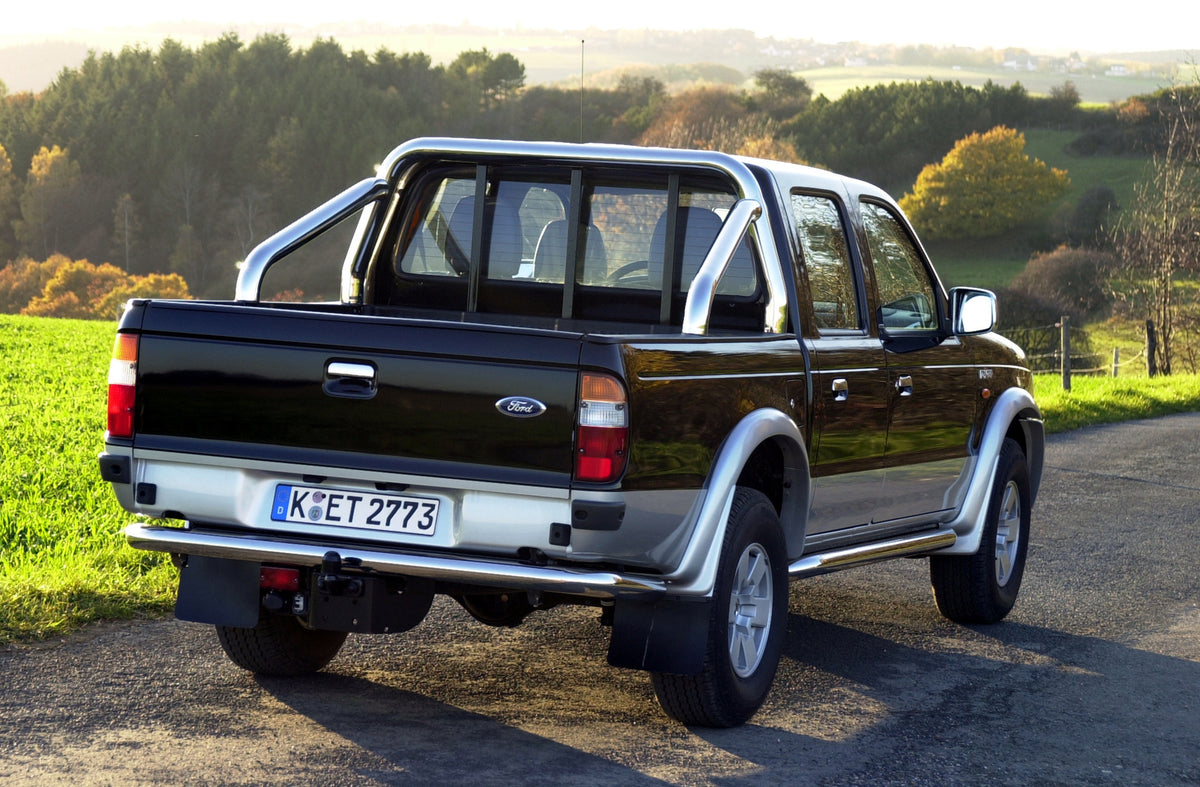 This archival image documents the 2003 Ford Ranger XLT rear view on scenic road with trees and is preserved in the Ford Heritage Vault as part of Ford Motor Company's historic photographic archive. Free for personal, non-commercial use. Ford Herit...