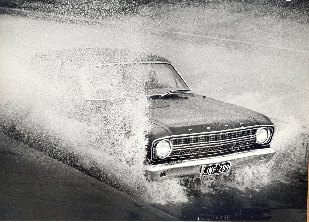 This archival image documents the 1966 Ford XR Falcon Sedan closeup action shot through puddle and is preserved in the Ford Heritage Vault as part of Ford Motor Company's historic photographic archive. Free for personal, non-commercial use. Ford H...
