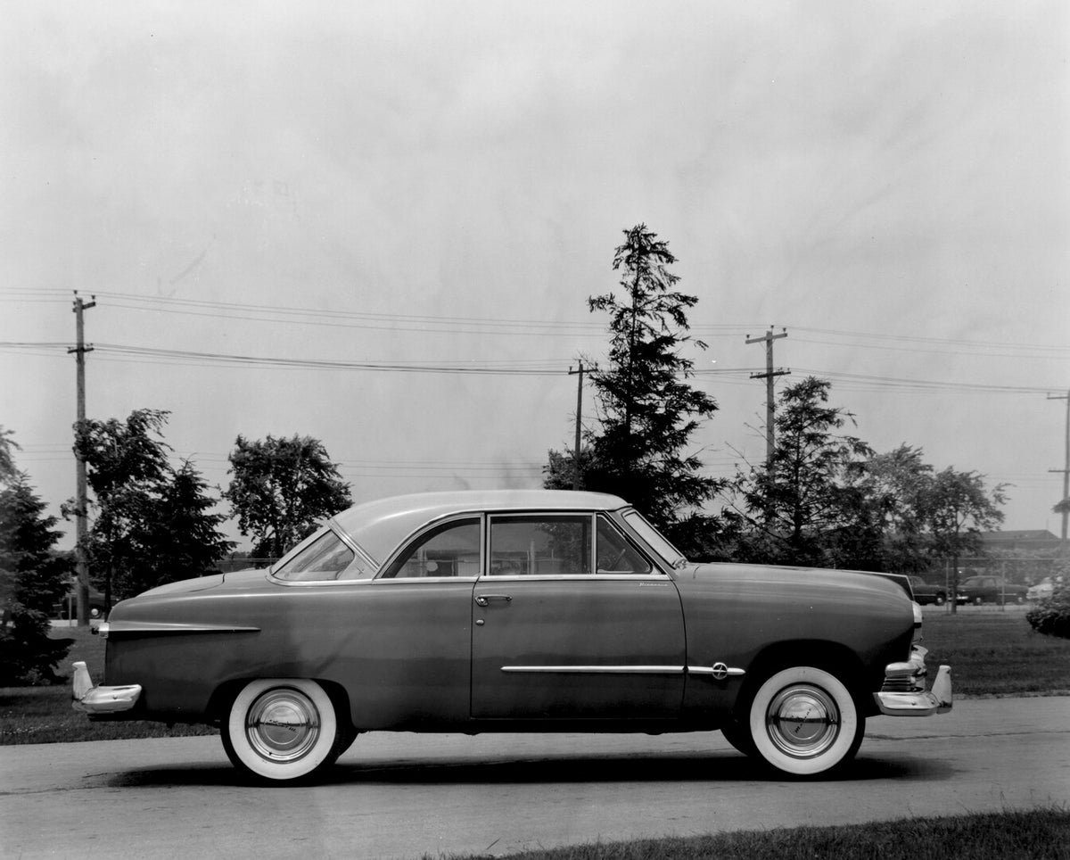 This archival image documents the 1951 Meteor Coupe side view on scenic road with trees AR-2007-5 and is preserved in the Ford Heritage Vault as part of Ford Motor Company's historic photographic archive. Free for personal, non-commercial use. For...
