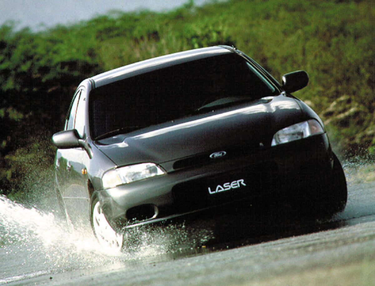 This archival image documents the 1999 Ford Laser action shot through scenic puddle and is preserved in the Ford Heritage Vault as part of Ford Motor Company's historic photographic archive. Free for personal, non-commercial use. Ford Heritage Vau...