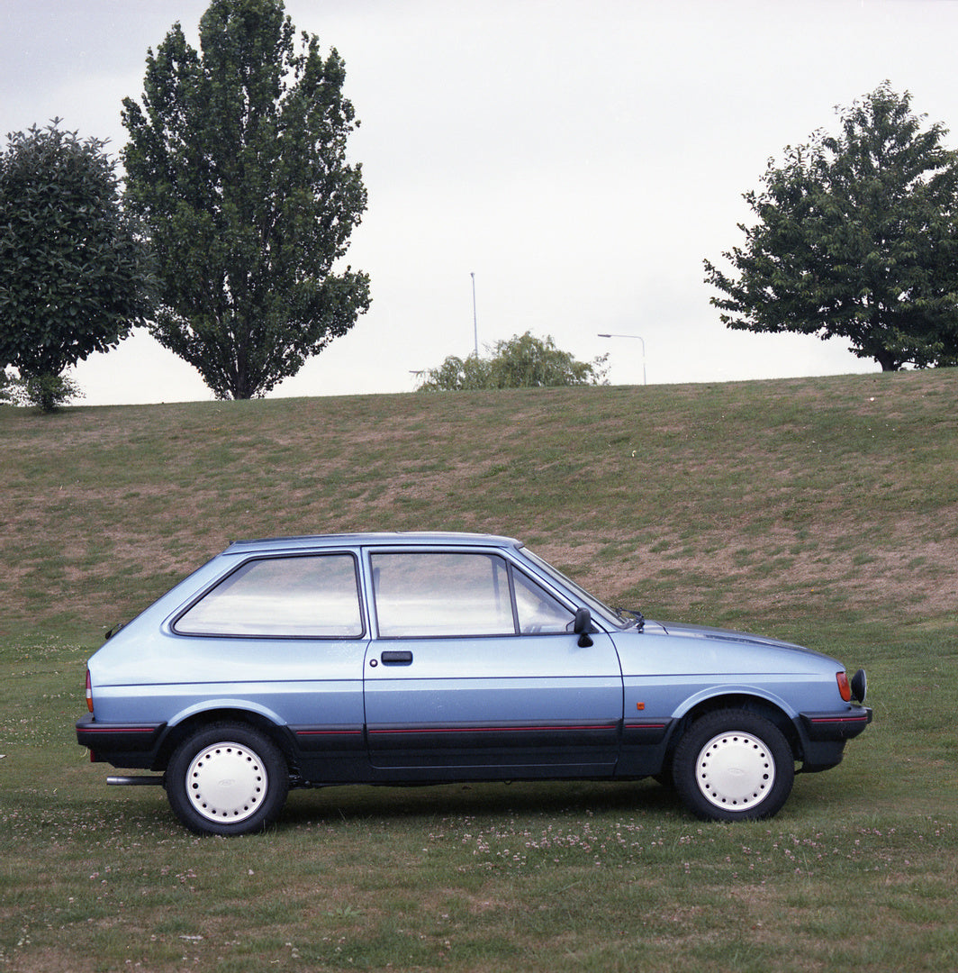 This archival image documents the 1986 Ford Fiesta Mark II 1.4 S side view in scenic field with trees and is preserved in the Ford Heritage Vault as part of Ford Motor Company's historic photographic archive. Free for personal, non-commercial use....