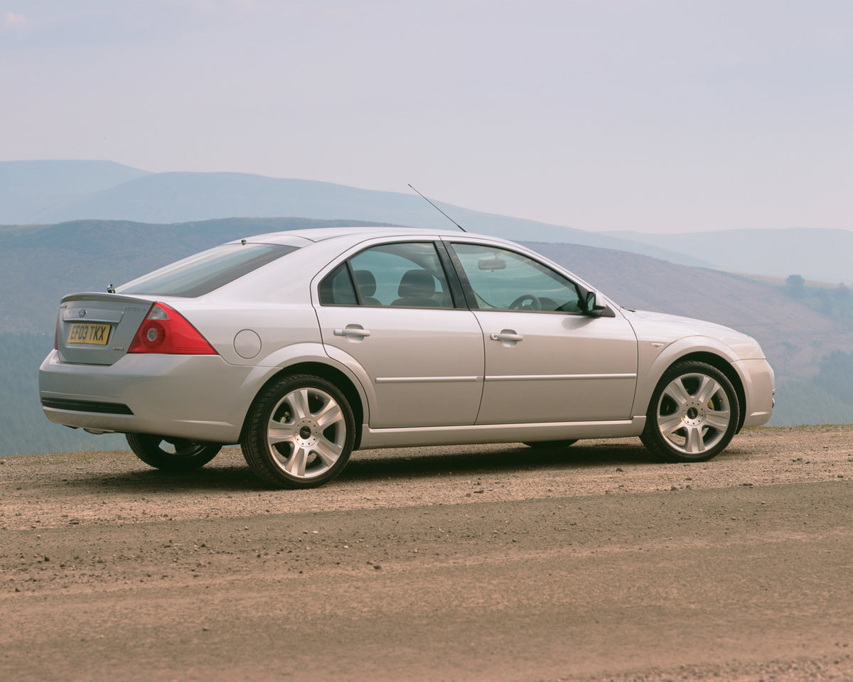 This archival image documents the 2003 Ford Mondeo Zetec Mark II side view with scenic hills and is preserved in the Ford Heritage Vault as part of Ford Motor Company's historic photographic archive. Free for personal, non-commercial use. Ford Her...