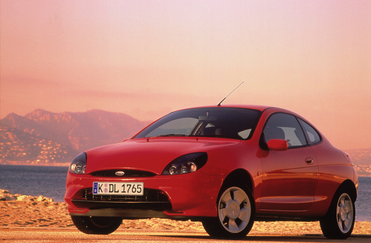This archival image documents the 1997 Ford Puma on scenic beach with mountains and is preserved in the Ford Heritage Vault as part of Ford Motor Company's historic photographic archive. Free for personal, non-commercial use. Ford Heritage Vault r...