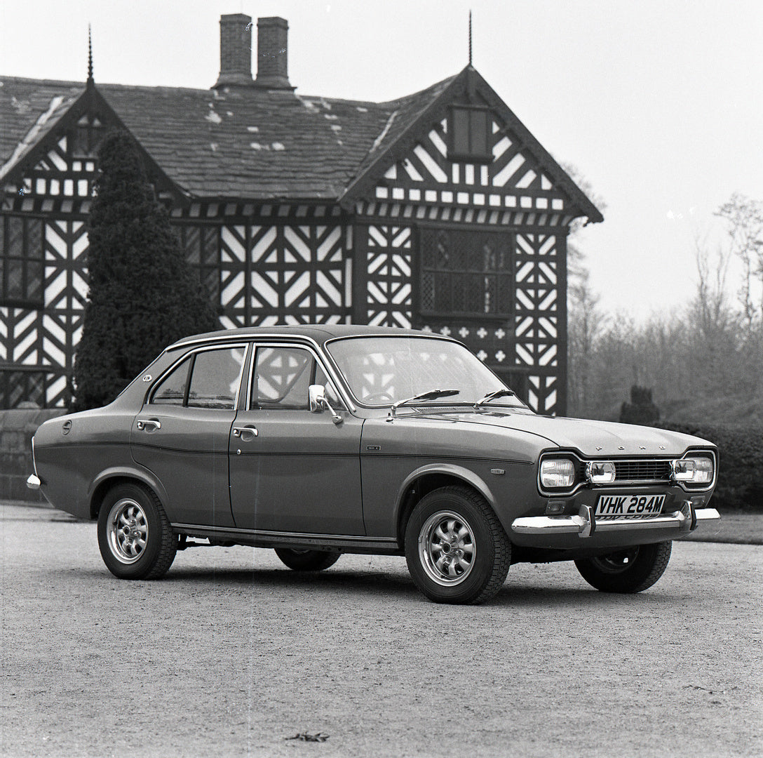 This archival image documents the 1974 Ford Escort Mark I 1300 E 4 Door in front of scenic house with trees and is preserved in the Ford Heritage Vault as part of Ford Motor Company's historic photographic archive. Free for personal, non-commercia...