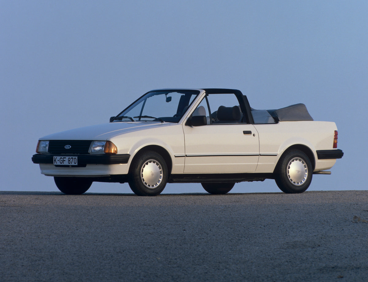 This archival image documents the 1984 Ford Escort Mark III Cabriolet with scenic blue sky and is preserved in the Ford Heritage Vault as part of Ford Motor Company's historic photographic archive. Free for personal, non-commercial use. Ford Herit...