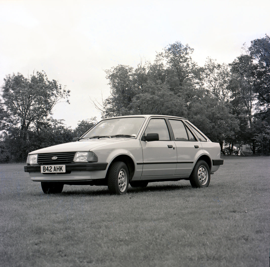 This archival image documents the 1985 Ford Escort Mark III XR3i in scenic field with trees and is preserved in the Ford Heritage Vault as part of Ford Motor Company's historic photographic archive. Free for personal, non-commercial use. Ford Heri...