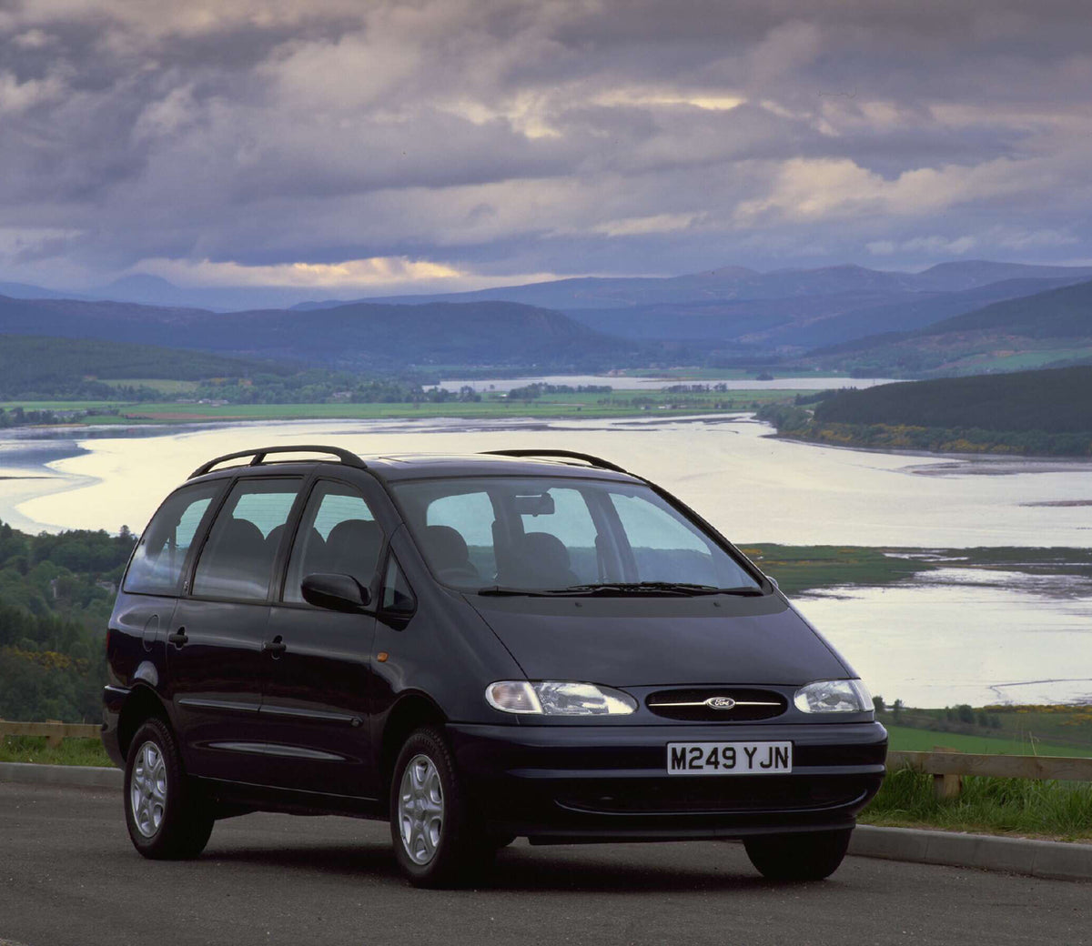 This archival image documents the 1995 Ford Galaxy Mark I Ghia on scenic road with river valley AR-2002-213709 and is preserved in the Ford Heritage Vault as part of Ford Motor Company's historic photographic archive. Free for personal, non-commer...