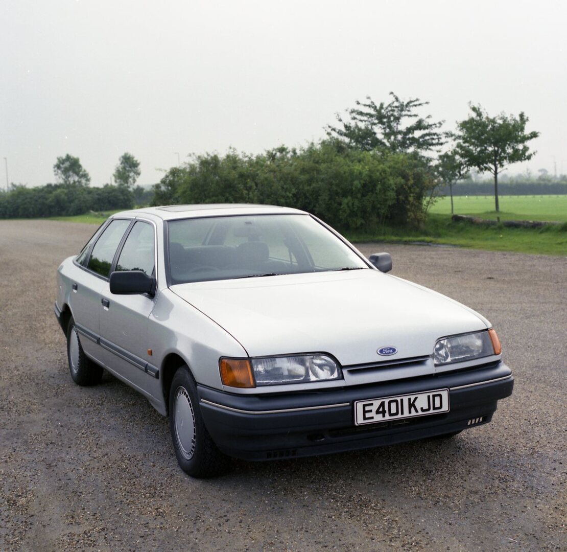 This archival image documents the 1987 Ford Granada Mark III GL front view on scenic road and is preserved in the Ford Heritage Vault as part of Ford Motor Company's historic photographic archive. Free for personal, non-commercial use. Ford Herita...