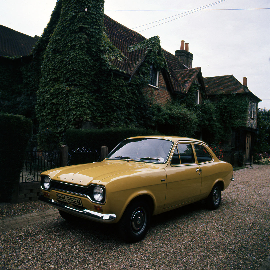 This archival image documents the 1974 Ford Escort Mark I 1100 L in front of scenic house and is preserved in the Ford Heritage Vault as part of Ford Motor Company's historic photographic archive. Free for personal, non-commercial use. Ford Herita...