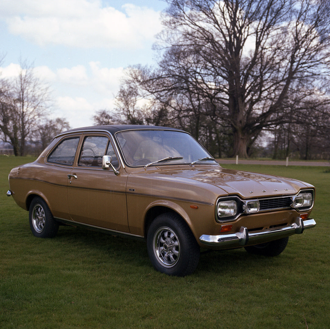 This archival image documents the 1973 Ford Escort Mark I 1300 E 2 Door Amber Gold in scenic field and is preserved in the Ford Heritage Vault as part of Ford Motor Company's historic photographic archive. Free for personal, non-commercial use. Fo...