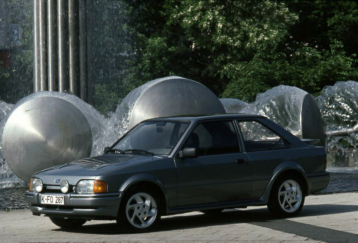 This archival image documents the 1986 Ford Escort Mark IV Turbo LHD in front of sculpture and is preserved in the Ford Heritage Vault as part of Ford Motor Company's historic photographic archive. Free for personal, non-commercial use. Ford Herit...