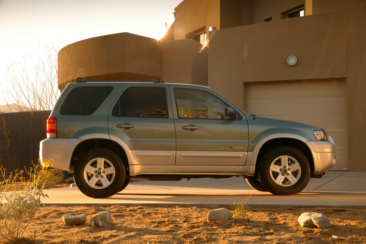 This archival image documents the 2005 Ford Escape Hybrid in front of house and is preserved in the Ford Heritage Vault as part of Ford Motor Company's historic photographic archive. Free for personal, non-commercial use. Ford Heritage Vault refer...