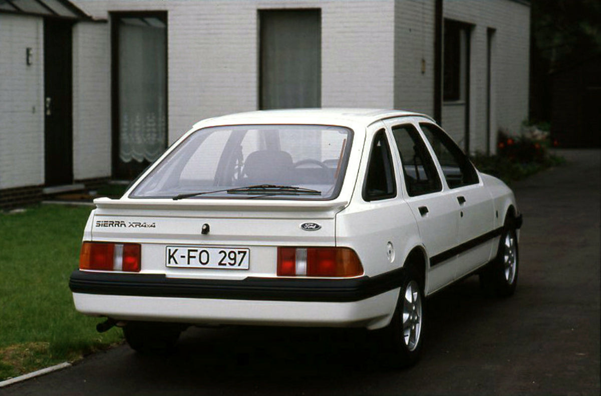 This archival image documents the 1985 Ford Sierra XR 4x4 LHD rear view closeup in driveway and is preserved in the Ford Heritage Vault as part of Ford Motor Company's historic photographic archive. Free for personal, non-commercial use. Ford Heri...