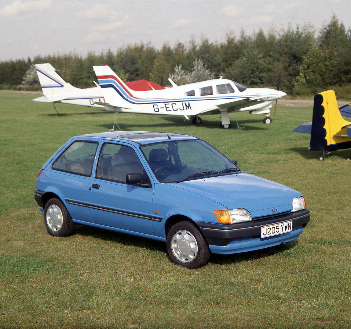 This archival image documents the 1991 Ford Fiesta Mark III 1.1 LX closeup with plane and scenic trees and is preserved in the Ford Heritage Vault as part of Ford Motor Company's historic photographic archive. Free for personal, non-commercial use...