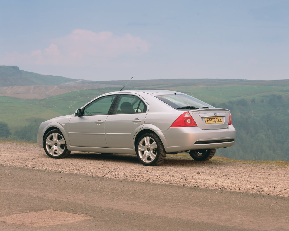 This archival image documents the 2003 Ford Mondeo Zetec Mark II rear view with scenic hills and is preserved in the Ford Heritage Vault as part of Ford Motor Company's historic photographic archive. Free for personal, non-commercial use. Ford Her...