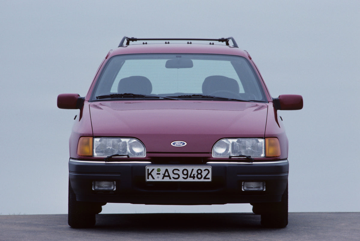 This archival image documents the 1987 Ford Seria 2.0 Ghia front view with scenic blue sky and is preserved in the Ford Heritage Vault as part of Ford Motor Company's historic photographic archive. Free for personal, non-commercial use. Ford Herit...